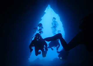 Diving through cave arch, Crete